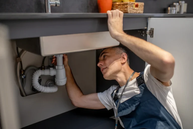plumber repair experienced attentive middleaged man examining bottom kitchen sink