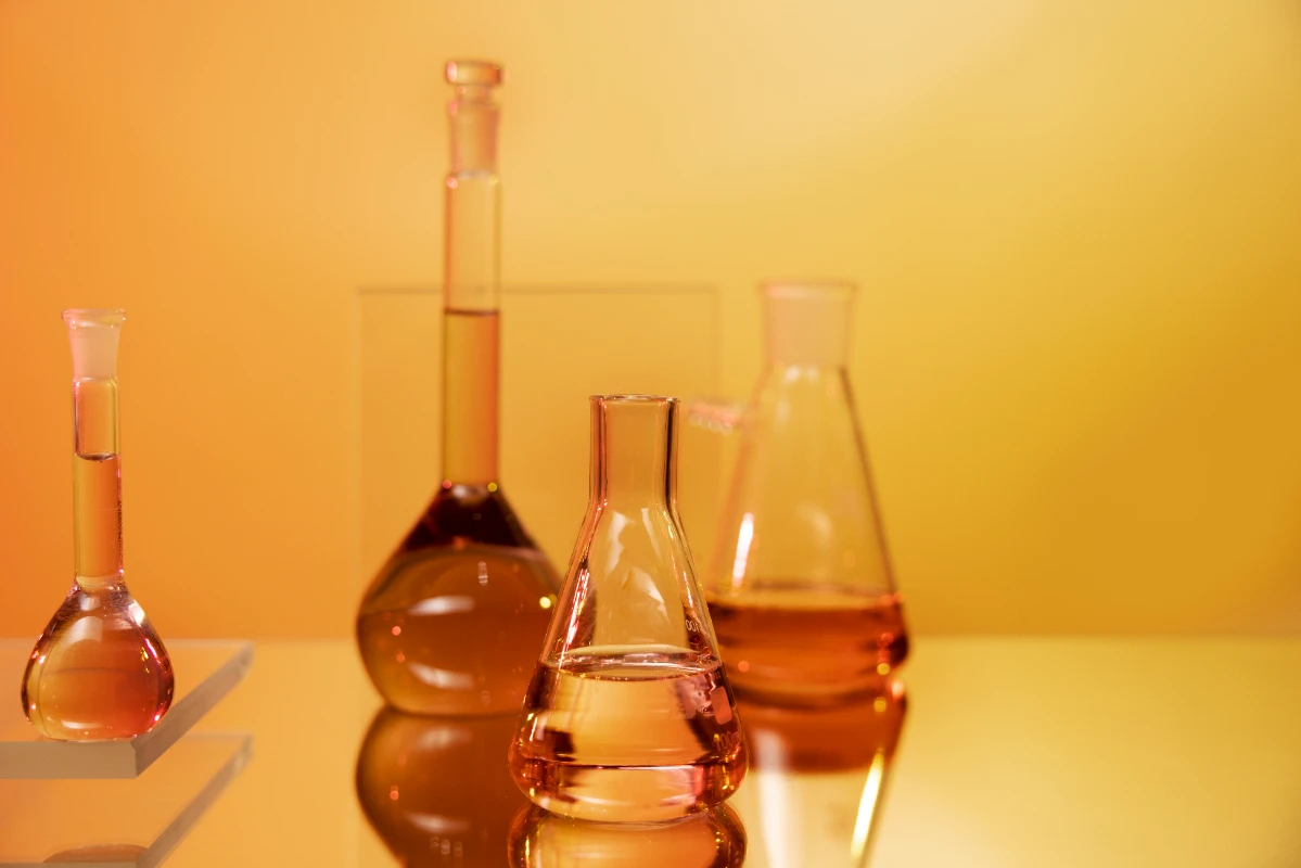 laboratory glassware arrangement with orange liquids
