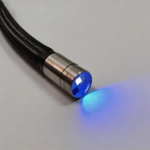 Macro shot of braided flexible borescope cable with metallic stainless steel probe head, built-in UV LED emitting blue ultraviolet light on neutral grey background