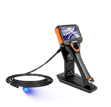Ergonomic orange-black handheld motorized articulation borescope kit on charging stand, equipped with flexible UV LED probe emitting blue ultraviolet light for fluorescent penetrant crack inspection