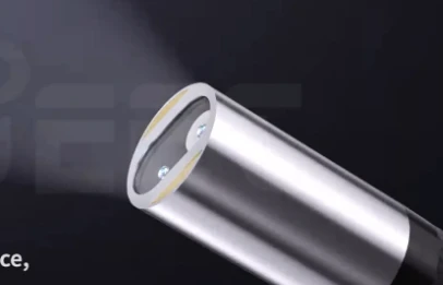 Close-up of metallic flexible video borescope probe tip equipped with two built-in LED lights, emitting light for dark cavity non-destructive visual testing