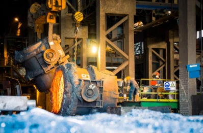 Steel mill factory scene with molten hot metal pouring in heavy‑industry workshop